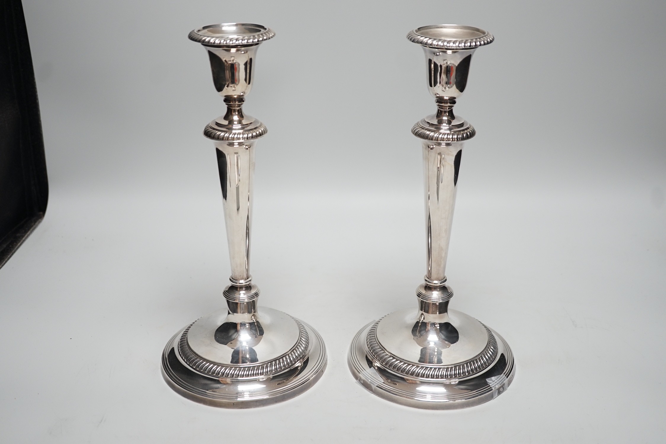 A pair of 1940's silver mounted candlesticks, by Mappin & Webb, height 27.7cm, weighted.